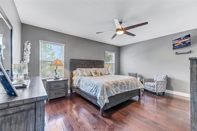 bedroom featuring multiple windows, a textured ceiling, dark wood-type flooring, and ceiling fan