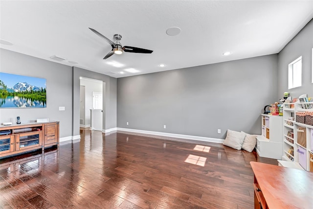 living room with dark wood-type flooring and ceiling fan