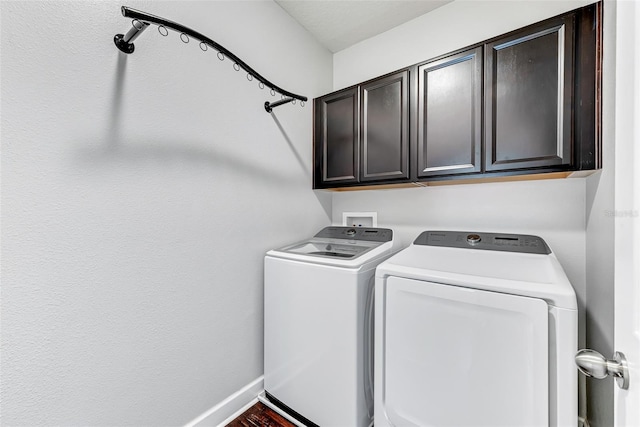 washroom with cabinets and washing machine and clothes dryer