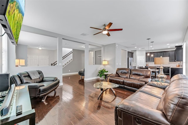 living room featuring ceiling fan and dark hardwood / wood-style flooring