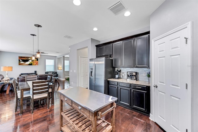 kitchen featuring dark wood-type flooring, ceiling fan, backsplash, light stone countertops, and stainless steel fridge with ice dispenser