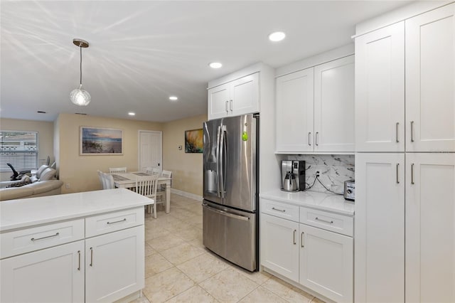 kitchen featuring decorative backsplash, white cabinets, light tile patterned flooring, stainless steel fridge with ice dispenser, and decorative light fixtures