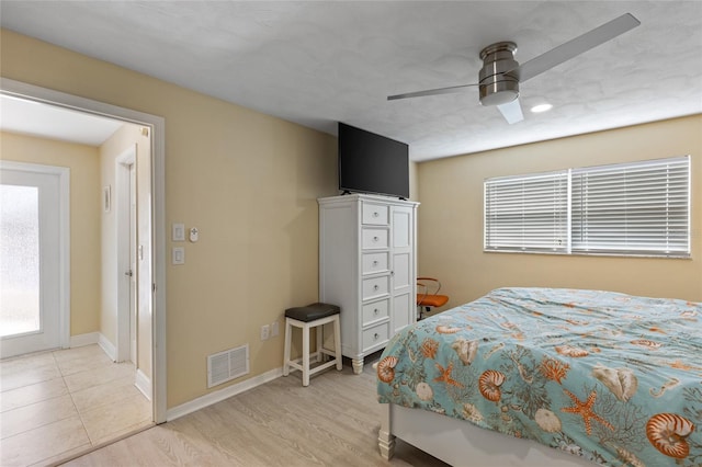 bedroom featuring ceiling fan, multiple windows, and light wood-type flooring