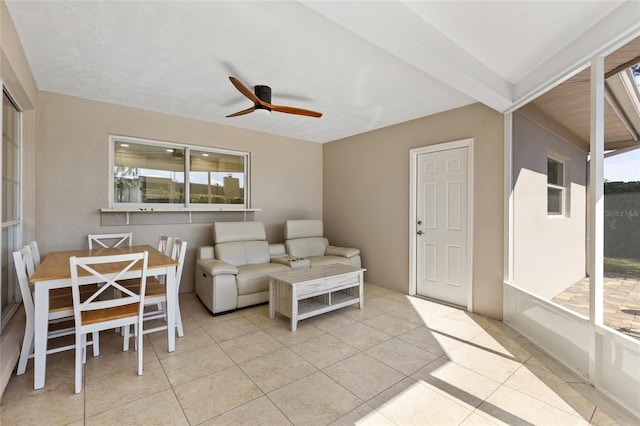 tiled living room with a wealth of natural light, beamed ceiling, and ceiling fan