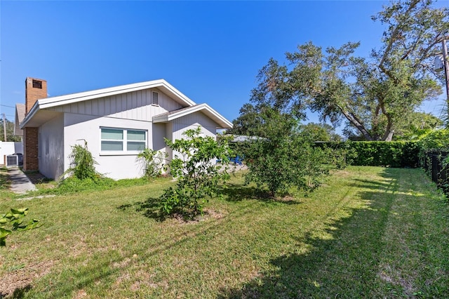 exterior space featuring central AC unit and a lawn