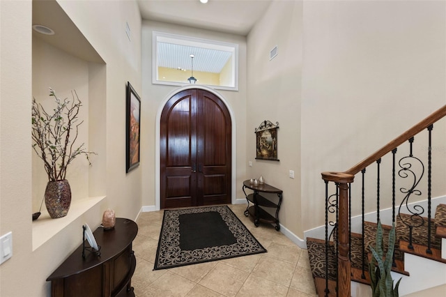 tiled entrance foyer featuring a high ceiling