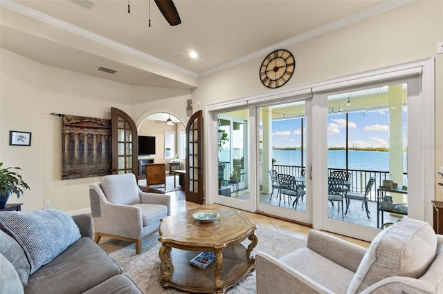 tiled living room with crown molding, french doors, and ceiling fan