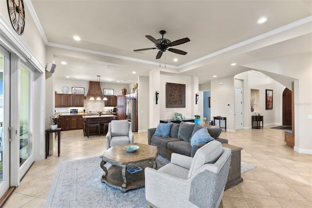 living room with crown molding, light tile patterned floors, and ceiling fan