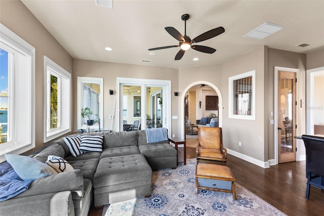 living room with dark hardwood / wood-style floors and ceiling fan