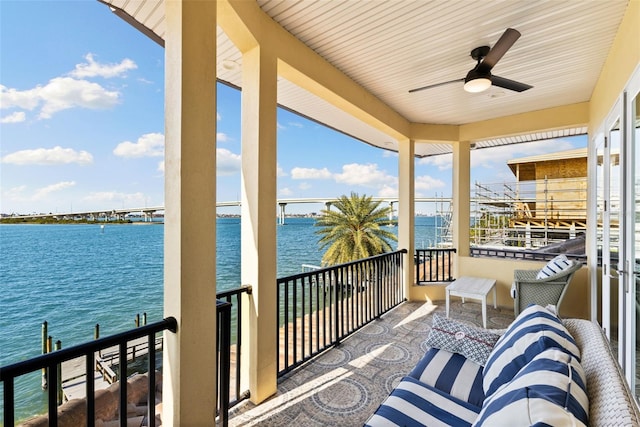 balcony featuring a water view and ceiling fan