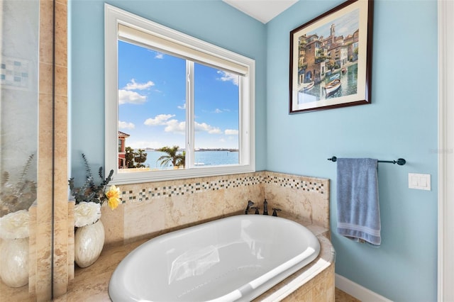 bathroom with a water view and tiled bath