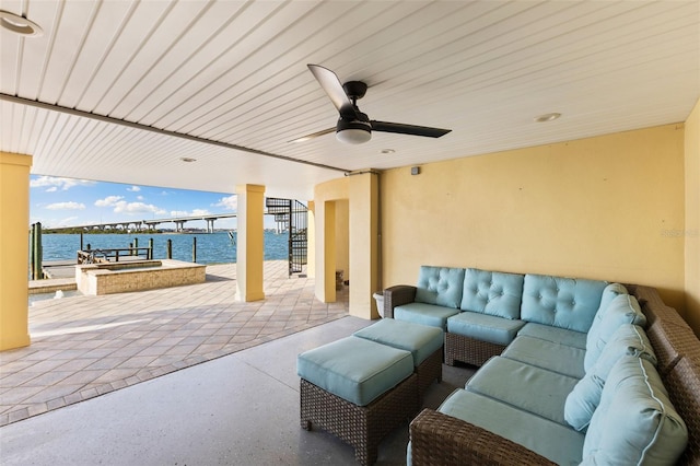 view of patio with an outdoor living space, a water view, and ceiling fan