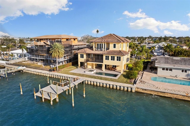 rear view of house featuring a patio, a balcony, and a water view