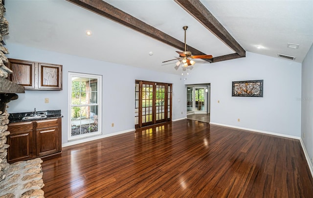 unfurnished living room with dark wood-type flooring, plenty of natural light, sink, and lofted ceiling with beams