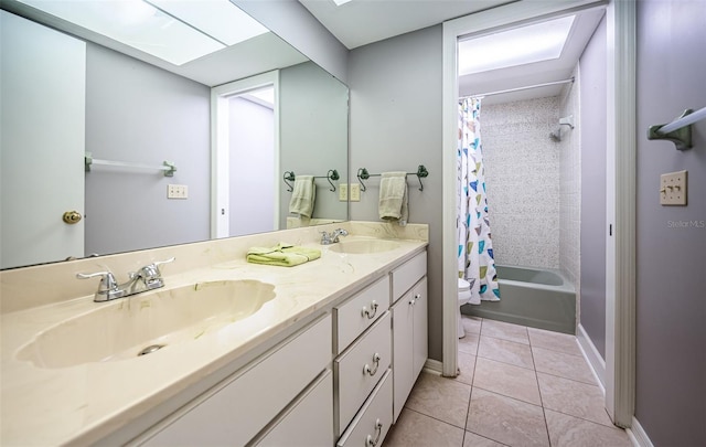 full bathroom featuring a skylight, shower / bath combination with curtain, vanity, toilet, and tile patterned floors