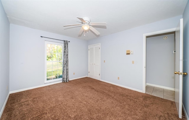 unfurnished room featuring ceiling fan and carpet floors