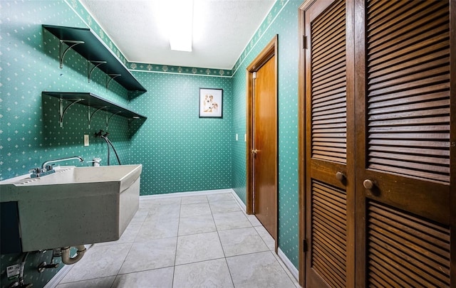 laundry room featuring light tile patterned floors and a textured ceiling