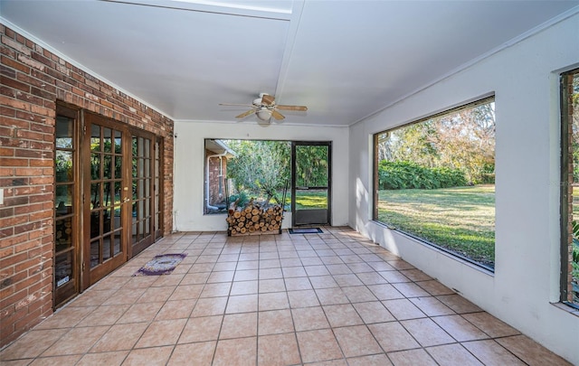 unfurnished sunroom with ceiling fan and a wealth of natural light