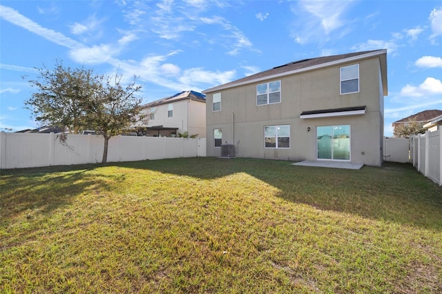 back of property with cooling unit and a yard