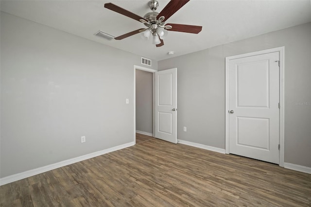 unfurnished bedroom featuring dark wood-type flooring and ceiling fan