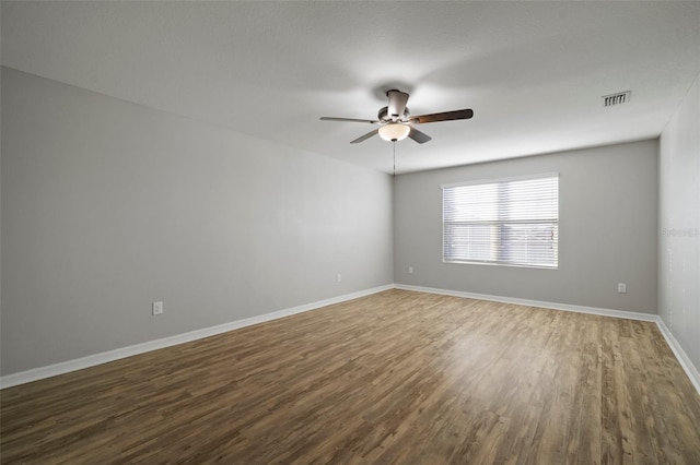 spare room featuring dark hardwood / wood-style flooring and ceiling fan