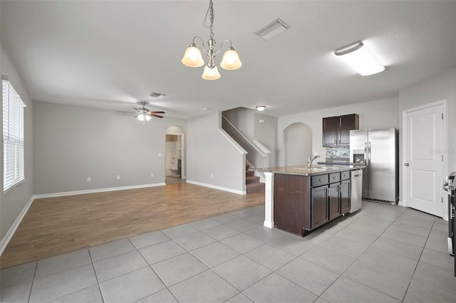 kitchen with decorative light fixtures, sink, light tile patterned floors, stainless steel appliances, and dark brown cabinets