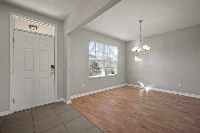 tiled entrance foyer with a notable chandelier