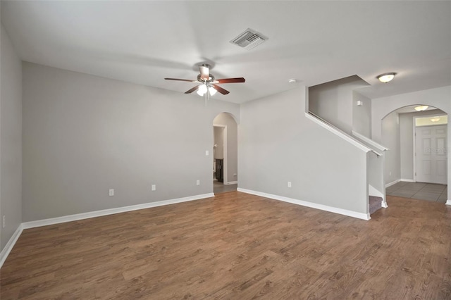 unfurnished living room with dark wood-type flooring and ceiling fan