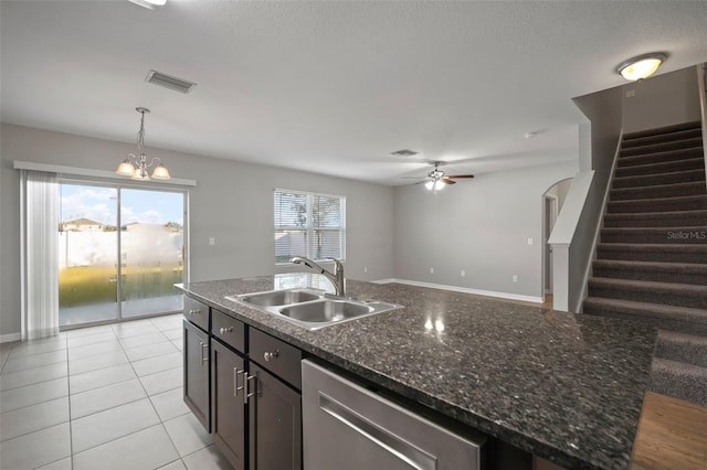 kitchen with sink, stainless steel dishwasher, pendant lighting, a healthy amount of sunlight, and a kitchen island with sink