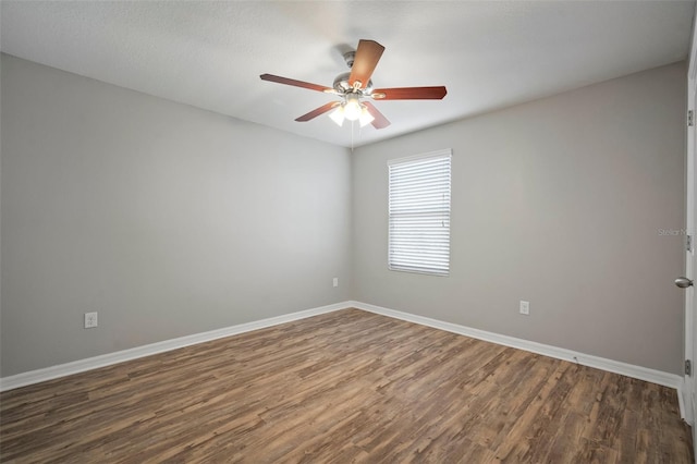 spare room featuring dark wood-type flooring and ceiling fan