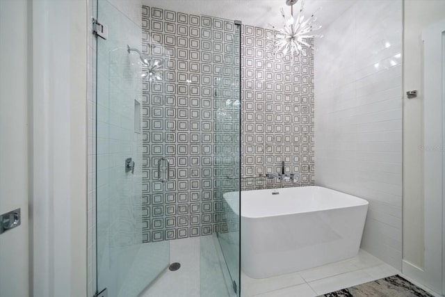 bathroom with tile patterned flooring, shower with separate bathtub, and a chandelier