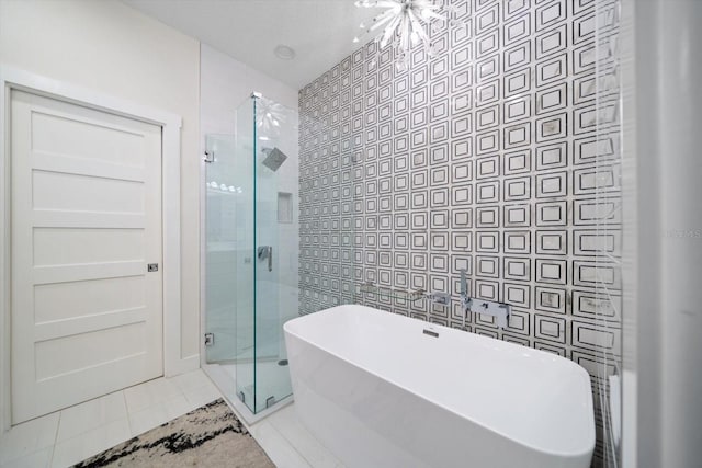 bathroom with tile patterned flooring, separate shower and tub, and an inviting chandelier