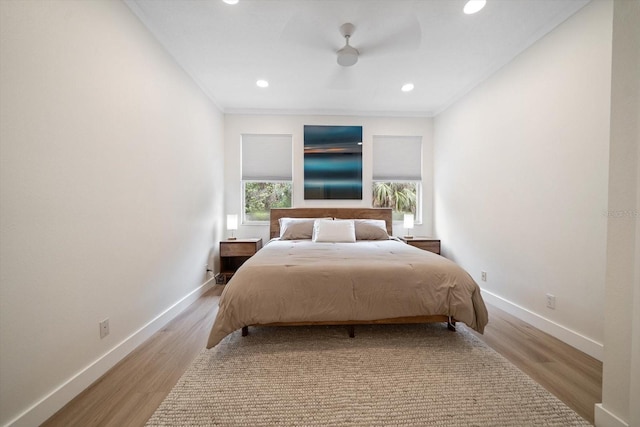 bedroom featuring light hardwood / wood-style flooring, ornamental molding, and ceiling fan