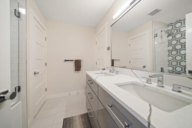 bathroom featuring tile patterned flooring, vanity, a textured ceiling, and walk in shower