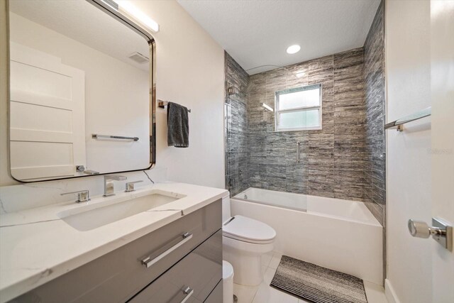 full bathroom with tiled shower / bath, vanity, toilet, and tile patterned flooring