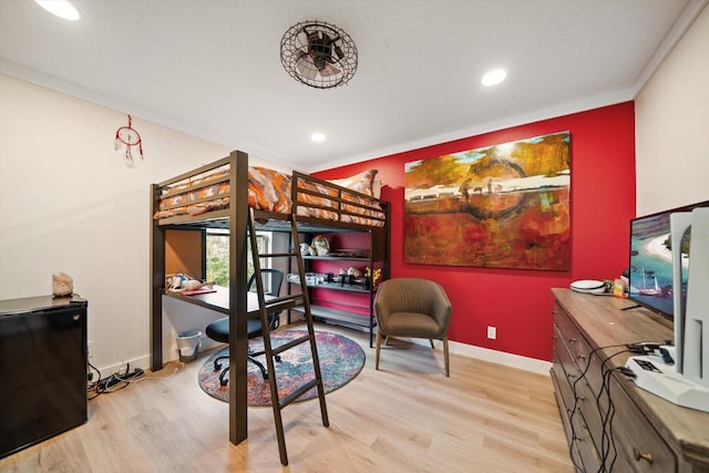 bedroom featuring ornamental molding and light hardwood / wood-style floors