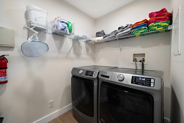 laundry room with hardwood / wood-style flooring and washing machine and clothes dryer