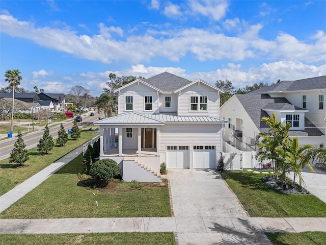 view of front of home featuring a porch, a residential view, driveway, and a front lawn