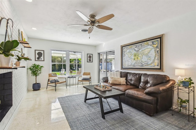 living room with ceiling fan and a fireplace