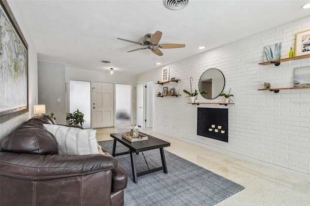 living room with ceiling fan and brick wall