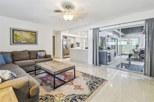 living room featuring ceiling fan and sink