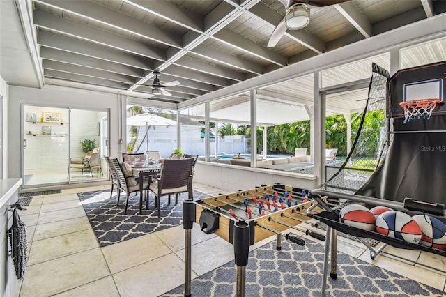 sunroom with beamed ceiling and ceiling fan