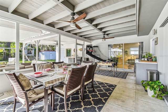 sunroom / solarium featuring ceiling fan and beam ceiling