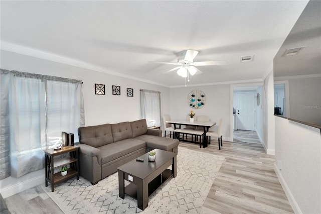 living room with crown molding, light hardwood / wood-style floors, and ceiling fan