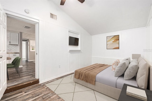 bedroom featuring hardwood / wood-style flooring, vaulted ceiling, and ceiling fan