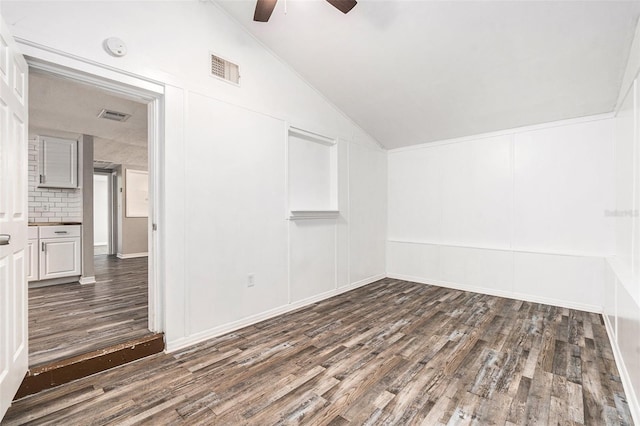 spare room featuring vaulted ceiling, dark wood-type flooring, and ceiling fan