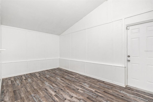 empty room featuring dark hardwood / wood-style flooring and vaulted ceiling