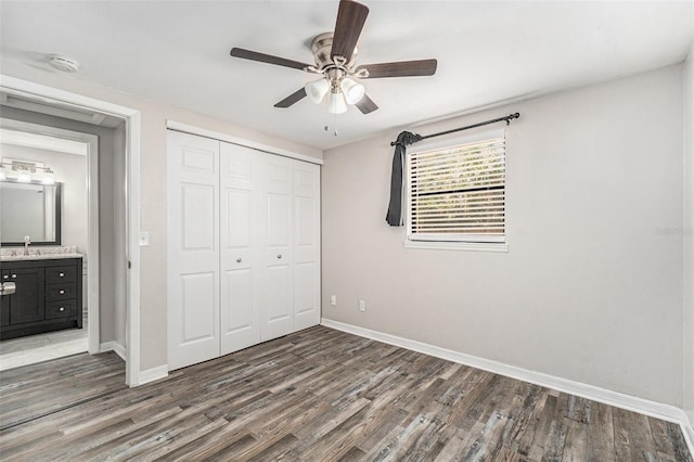 unfurnished bedroom with sink, a closet, dark hardwood / wood-style floors, and ceiling fan