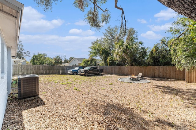 view of yard with cooling unit and an outdoor fire pit