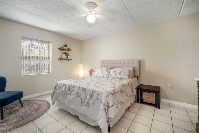 bedroom featuring ceiling fan, a textured ceiling, and light tile patterned floors